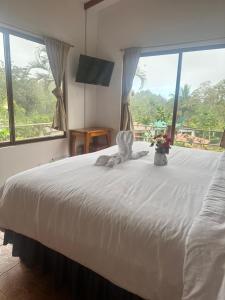 a bedroom with a large white bed with a window at Piedras Blancas Lodge in Puerto Ayora