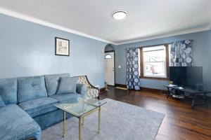 a living room with a blue couch and a television at College Duplex in Grand Rapids