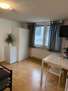 a living room with a desk and a table and a window at Nest-Unterkunft in Bad Überkingen