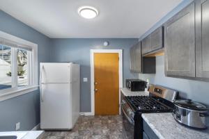 a kitchen with a refrigerator and a stove at College Duplex in Grand Rapids