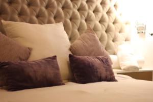 a bed with a large padded headboard and pillows at Casa Mestiza in Guadalajara