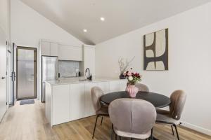 a kitchen and dining room with a table and chairs at Roam Taupo Upper Terrace Unit 4 - Spa Pool in Taupo
