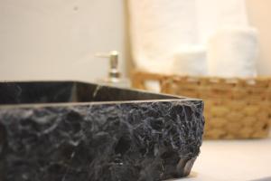 a black marble sink in a bathroom with a basket of paper towels at Casa Mestiza in Guadalajara