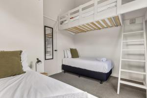 a bedroom with two beds and a loft bed at Roam Taupo Upper Terrace Unit 4 - Spa Pool in Taupo