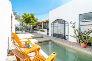 a house with a pool and two chairs and a table at Las Guapas Villas Tamarindo in Tamarindo