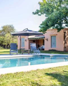 a pool with two chairs and a table and an umbrella at Los Narcisos in San Antonio de Areco