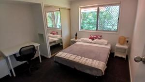 a bedroom with a bed and a desk and a mirror at Peaceful Country Home Between Brisbane & GC in Wolfdene