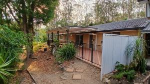 a house with a gate and a fence at Peaceful Country Home Between Brisbane & GC in Wolfdene