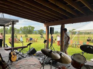 a man standing in front of a stage with drums and instruments at Yellowstone House in Livingston