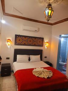 a bedroom with a bed with a red blanket at Dar Berrada-Ziat in Fez