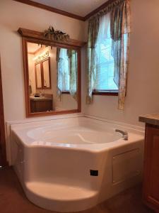 a large bath tub in a bathroom with a mirror at Pondview Escape a 75-Acre Retreat in Marion +30 photos