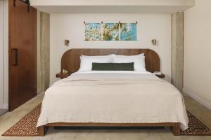 a bedroom with a large bed with a wooden headboard at Drift Nashville, a Member of Design Hotels in Nashville +59 photos