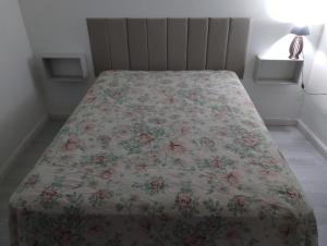 a bedroom with a bed with a floral bedspread at Cantinho da Paz in Socorro