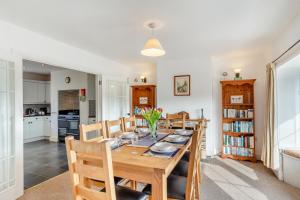 a dining room and kitchen with a wooden table and chairs at 4 Bed in Stokenham oc-i34021 in Stokenham