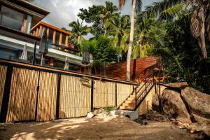 a house with a wooden fence and a staircase at Villa Amrita - Oceanfront Villa with Private Beach in Ko Phangan +117 photos