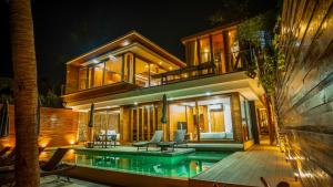 a house with a swimming pool next to a building at Villa Amrita - Oceanfront Villa with Private Beach in Ko Phangan