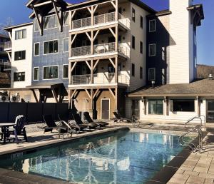 a building with a swimming pool in front of a building at Okemo Mountain Lodging by Vail Resorts in Ludlow
