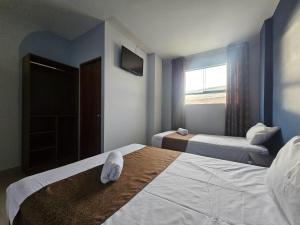 a hotel room with two beds and a window at Barlovento Business Hotel in Piura
