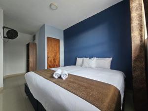 a bedroom with a large bed with two towels on it at Barlovento Business Hotel in Piura