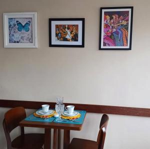 a table with two chairs and two pictures on the wall at Morada das Palmeiras in Barra Grande