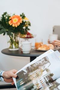 a person holding a magazine in front of a table at ARIA Collection Bari in Bari +39 photos