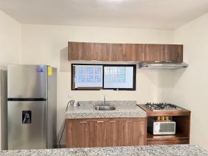 a kitchen with a stainless steel refrigerator and a sink at Casa completa , dos Habitaciones con baño en cada cuarto in Mérida