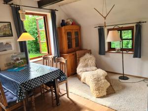a dining room with a table and a dog on a rug at Bauernhaus Sehestedt in Sehestedt +25 photos