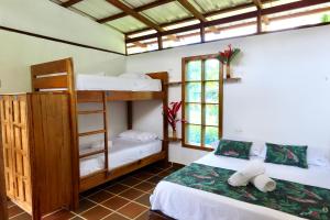 a room with two bunk beds and a window at Pacific Waves Hostel & Surf in El Valle +43 photos