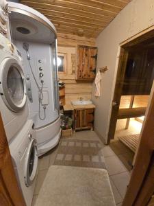 a bathroom with a washing machine and a sink at Tammetalu puhkemaja in Nõmme