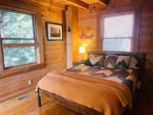 a bedroom with a bed in a log cabin at Turkey Ridge Retreat in Bryson City