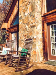 two rocking chairs on a porch of a stone building at Turkey Ridge Retreat in Bryson City
