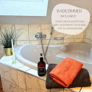 a bathroom with a bath tub with a towel and a bottle at Ferienhaus Landeskrone für 10 Personen mit Sauna, Terrasse, inkl Parkplatz in Dresden in Dresden