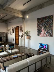 a living room with a couch and a tv at Lofty Hipster Penthouse in Johannesburg