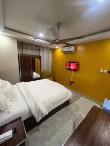 a bedroom with a bed and a yellow wall at Royal Galaxy Hotel in Kumasi