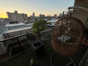 a bird cage on a balcony with a tree at Lofty Hipster Penthouse in Johannesburg
