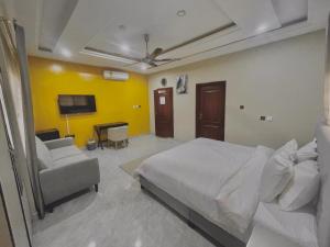 a bedroom with a bed and a couch and a tv at Royal Galaxy Hotel in Kumasi