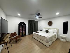 a bedroom with a bed and a chair and a toilet at Custom Tiny House in Valle in Francisco Zarco