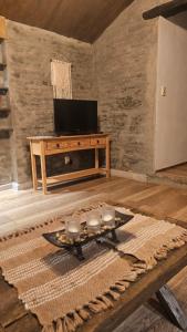 a living room with a tv and a table with candles at Morada La Granja in Minas