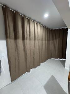 a room with brown curtains and a white tile floor at Refúgio Vila Mar Apto in Imbituba +25 photos