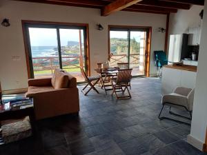 a living room with a kitchen and a table and chairs at Salga Lodge in Angra do Heroísmo