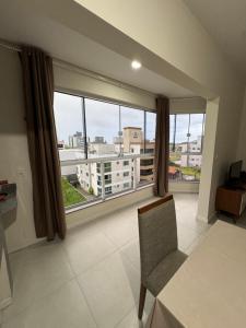 a living room with a large window with a view of a city at Refúgio Vila Mar Apto in Imbituba