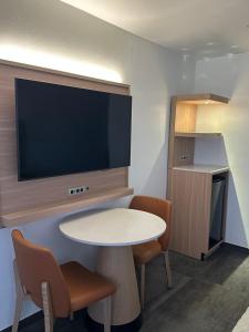 a room with a table and a flat screen tv at Nubell Motel in Bell +17 photos