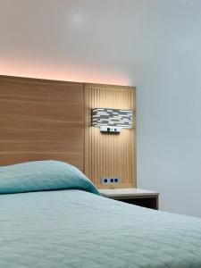 a bedroom with a bed with a wooden headboard at Nubell Motel in Bell