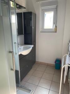 a bathroom with a sink and a mirror at House on Rue du Phare Town Center Hosted by Christine in Quiberon