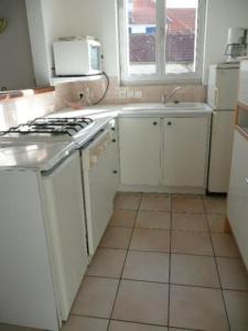 a kitchen with a white stove and a sink at House on Rue du Phare Town Center Hosted by Christine in Quiberon