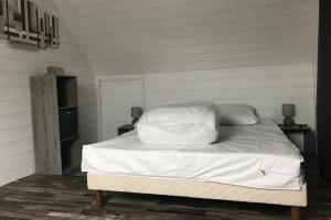 a bed with white sheets and pillows in a room at House on Rue du Phare Town Center Hosted by Christine in Quiberon