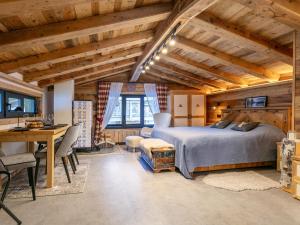 a bedroom with a bed and a desk in a room at Almversteck Hollersbach in Hollersbach im Pinzgau
