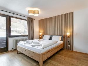 a bedroom with a large bed with white sheets at Brixen Alpin Living Top 18 in Brixen im Thale