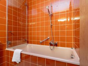a bath tub in a bathroom with orange tiles at Brixen Alpin Living Top 19 in Brixen im Thale +28 photos