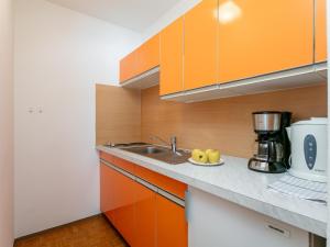 a kitchen with orange cabinets and a sink at Brixen Alpin Living Top 19 in Brixen im Thale